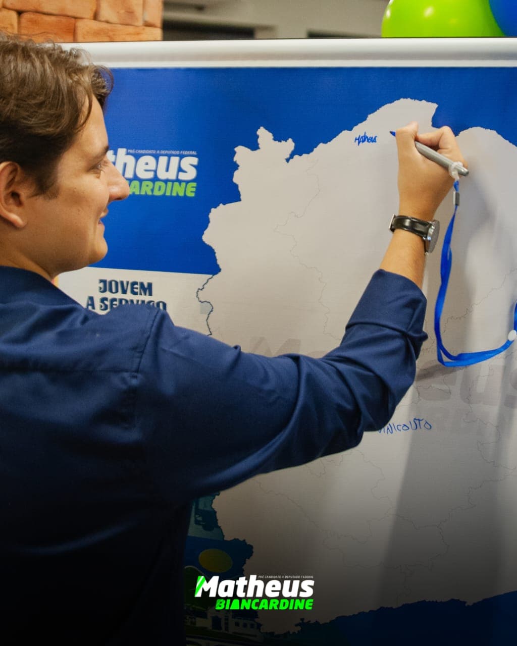 Matheus escrevendo seu nome em um mapa de Minas Gerais